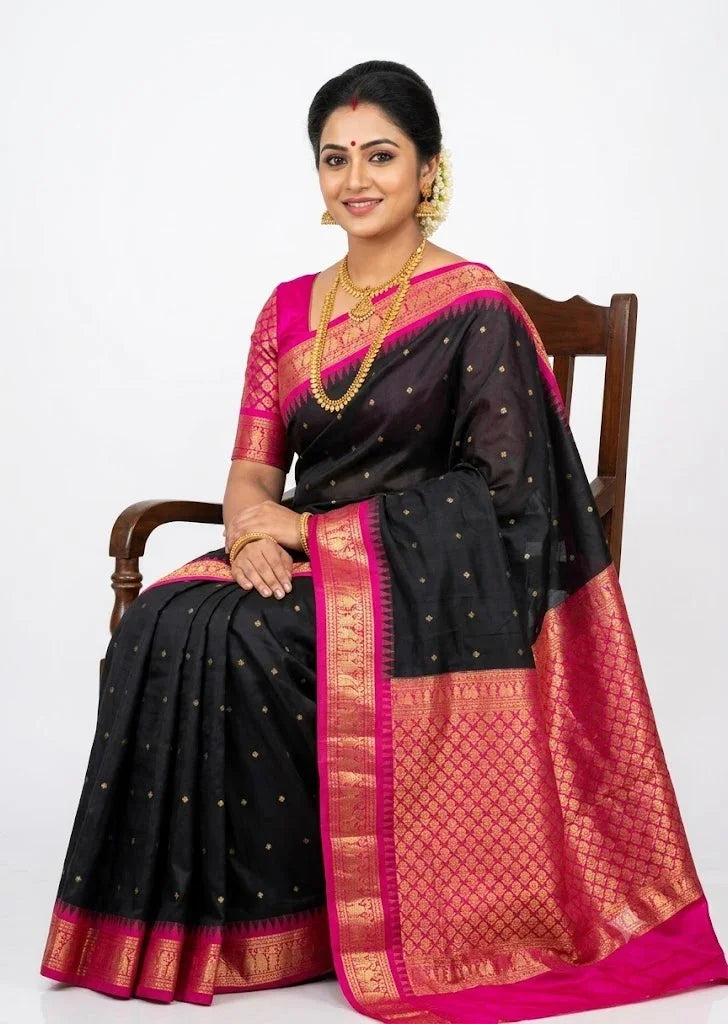 Traditional Indian woman seated on a chair wearing a black Gadwal silk saree with a pink zari pallu and blouse