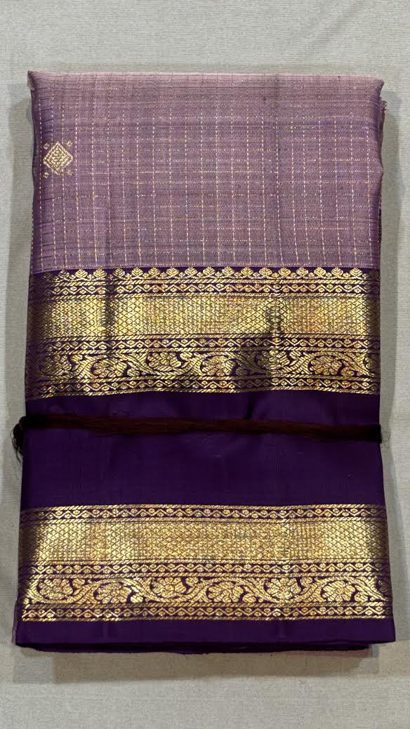 Close-up of a deep purple Kanchipuram saree pallu showcasing dense and intricate gold zari brocade work.