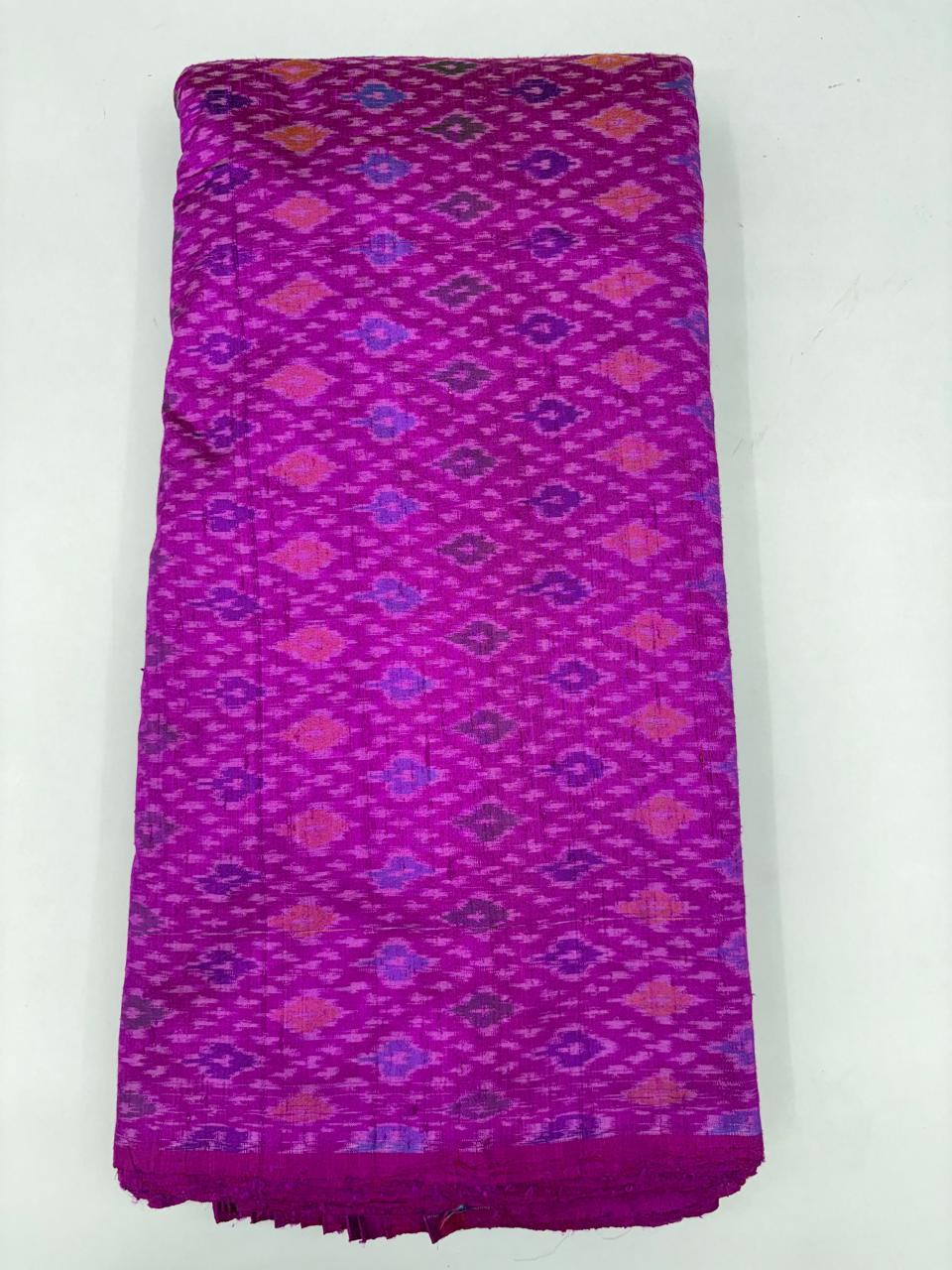 Folded bolt of vibrant magenta purple pure raw silk fabric featuring geometric diamond Ikat motifs with Silk Mark quality weave