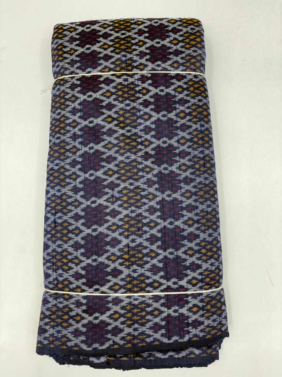 Folded bolt of navy blue pure raw silk fabric featuring an intricate geometric diamond lattice Ikat weave with Silk Mark authenticity