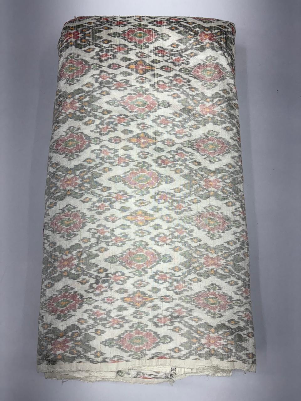 Folded bolt of off-white pure raw silk fabric featuring an intricate multicolor floral diamond Ikat weave with Silk Mark authenticity