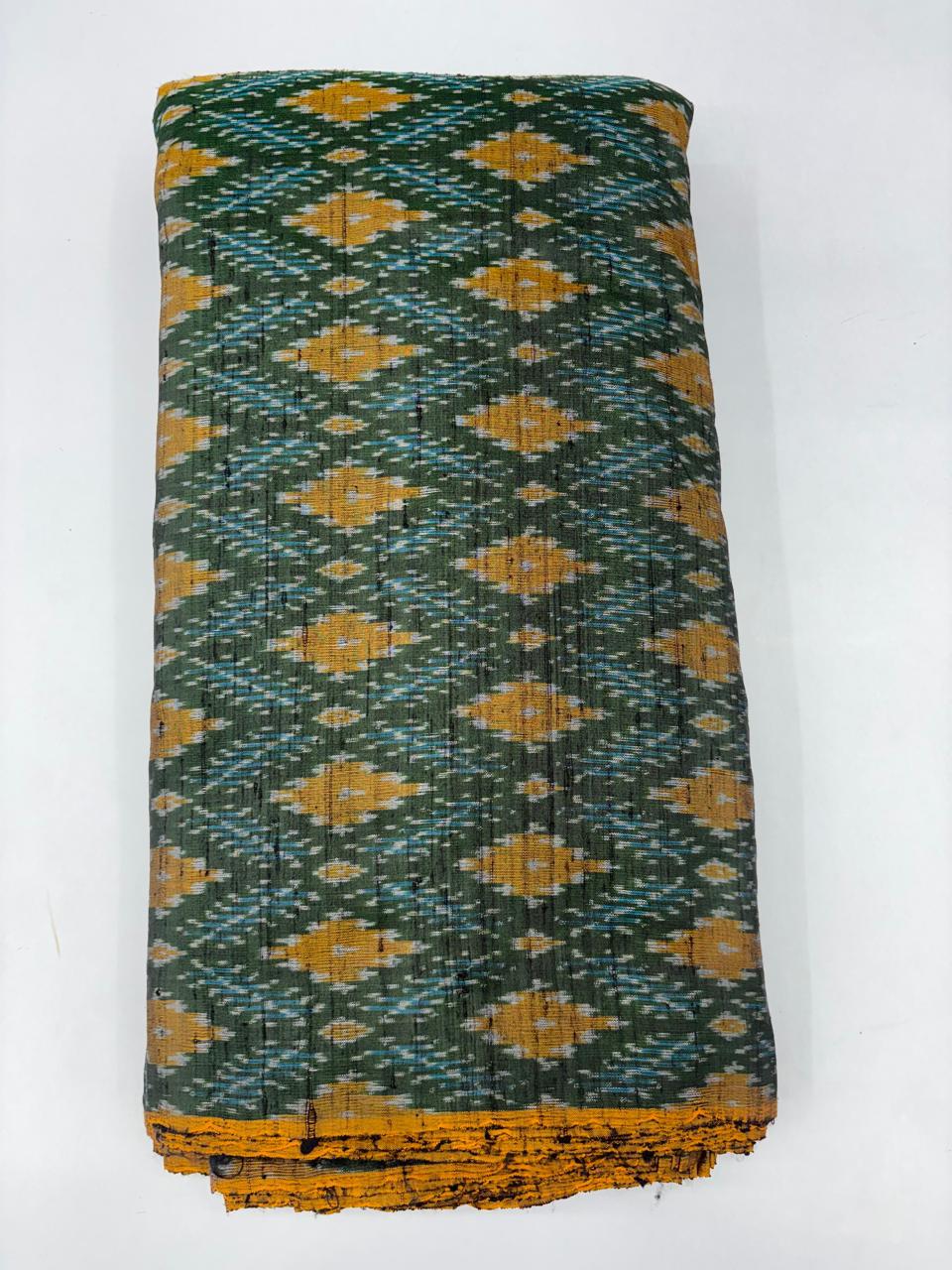 Folded bolt of olive green pure raw silk fabric patterned with mustard yellow diamond Ikat motifs and Silk Mark quality weave