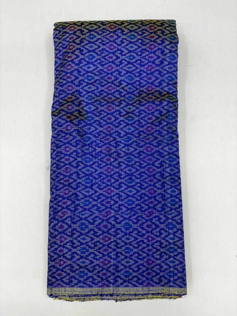 Folded bolt of royal blue pure raw silk fabric featuring an interlocking geometric diamond lattice Ikat weave with Silk Mark authenticity