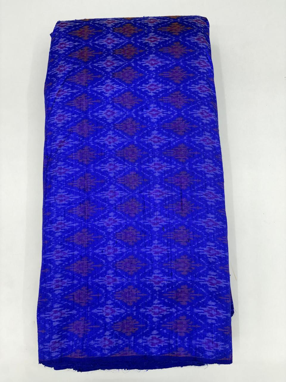 Folded bolt of royal blue pure raw silk fabric featuring purple and mauve geometric diamond Ikat motifs with Silk Mark quality weave