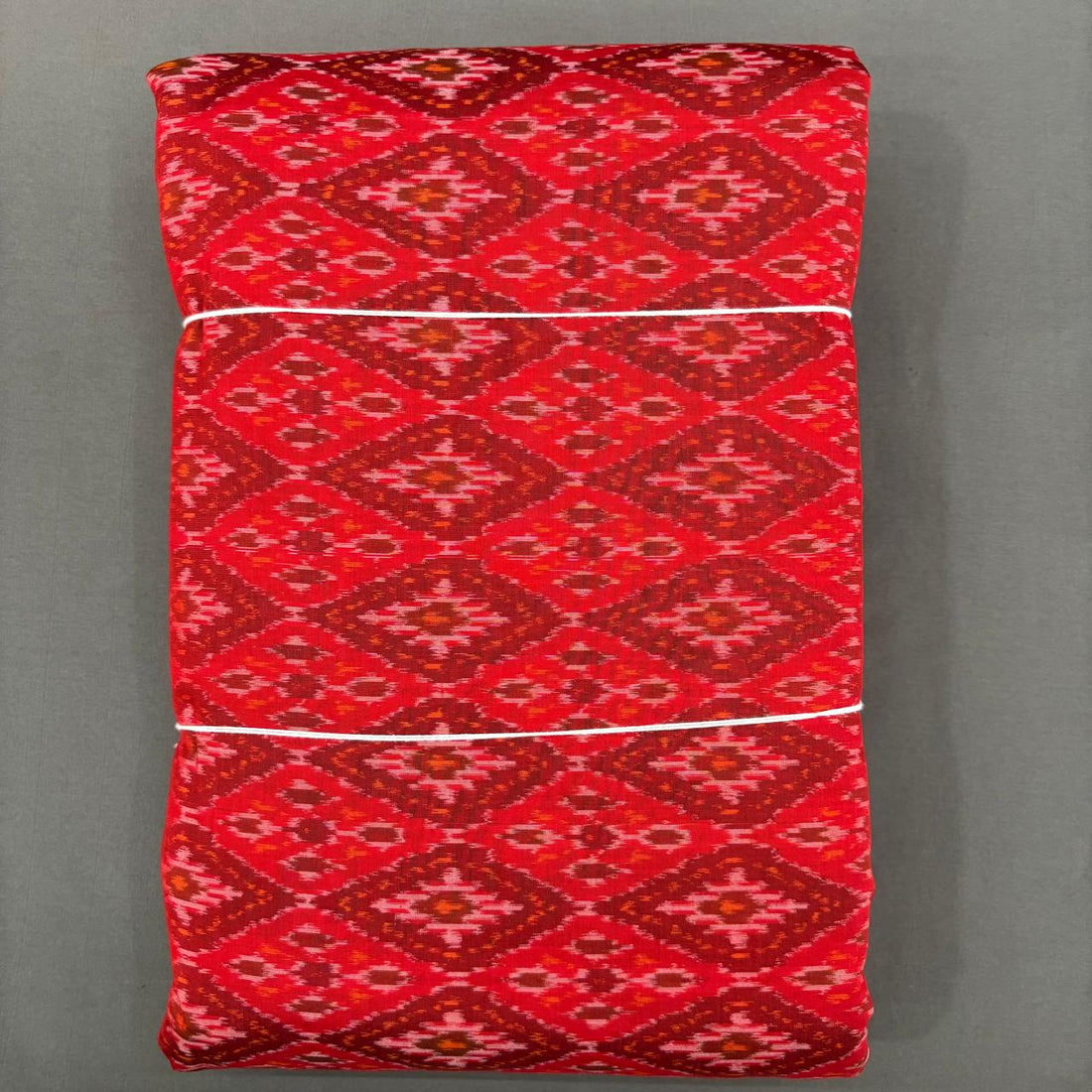 Rich red Pochampally ikkat sico unstitched dress material with a large geometric diamond pattern.