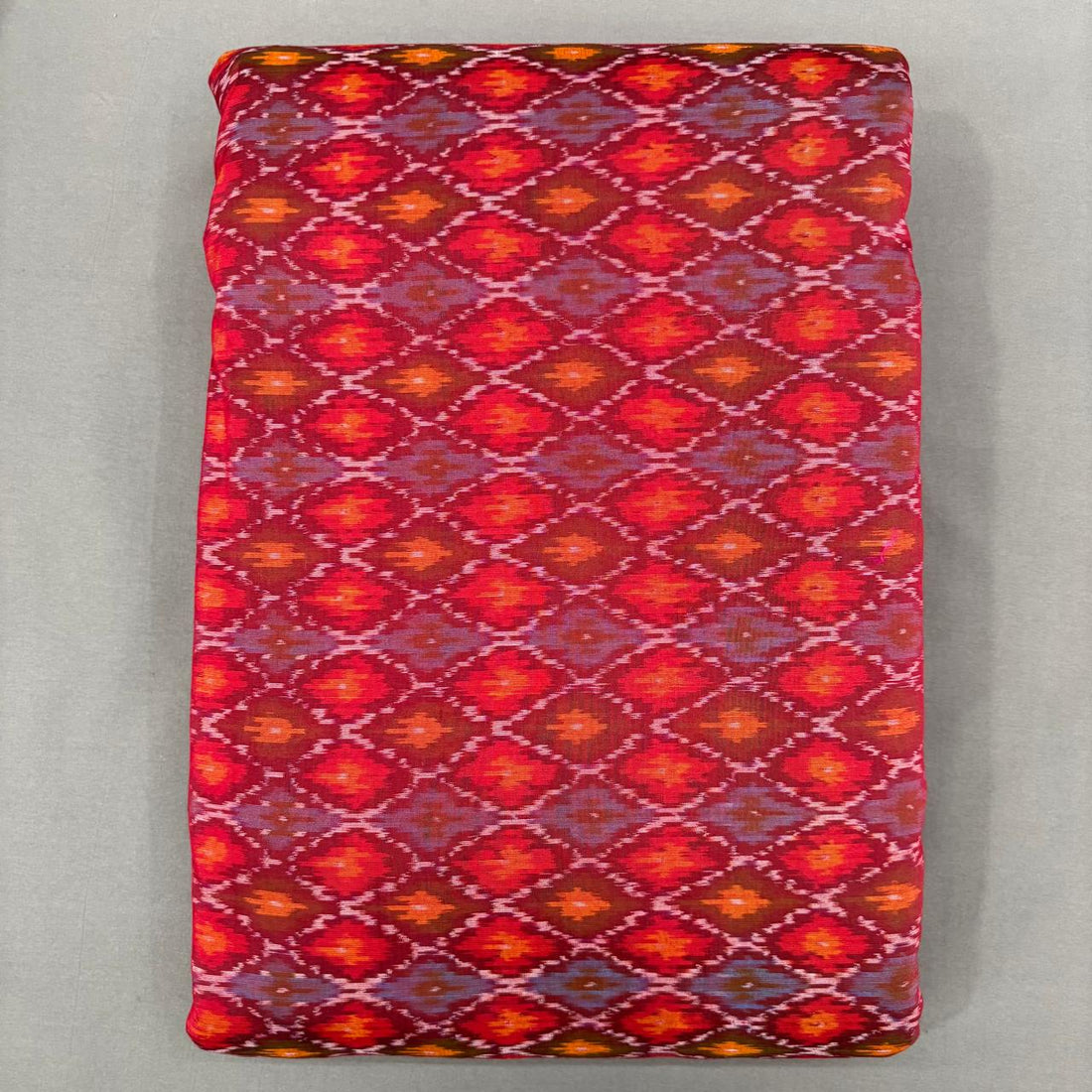 Dark red and orange Pochampally ikkat sico unstitched dress material with a geometric diamond pattern.