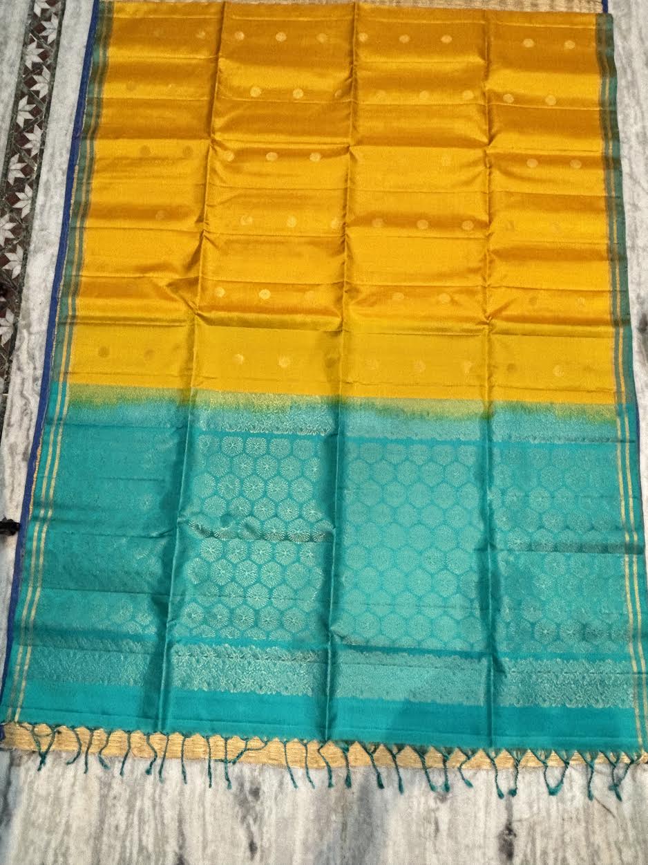 Silk Mark certified mustard yellow Kanchi soft silk saree featuring gold coin buttas and a rich peacock teal brocade pallu with tassels