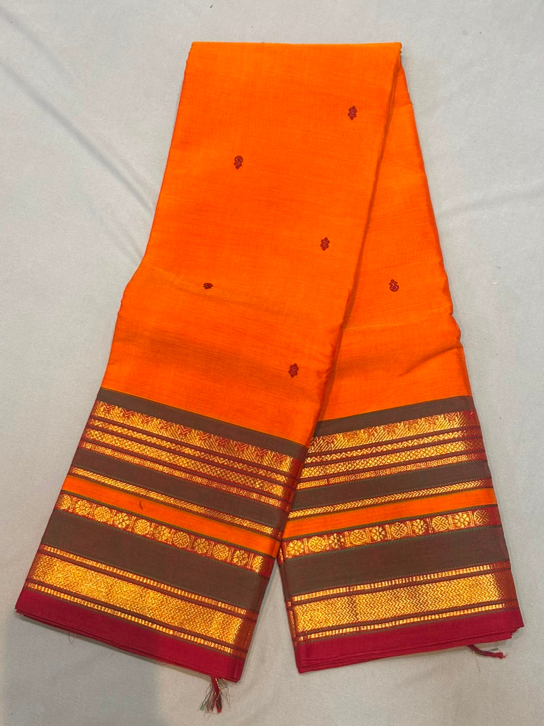 Handloom tangerine orange pure Kanchi cotton saree with maroon floral buttas and charcoal grey gold zari striped border