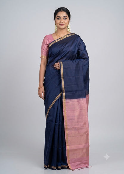 Elevate your festive wardrobe with this stunning navy blue handloom silk saree. It features a beautiful pastel pink contrasting pallu and blouse, finished with a classic gold zari border. Perfect for weddings, festivals, and special occasions. Buy online now!
