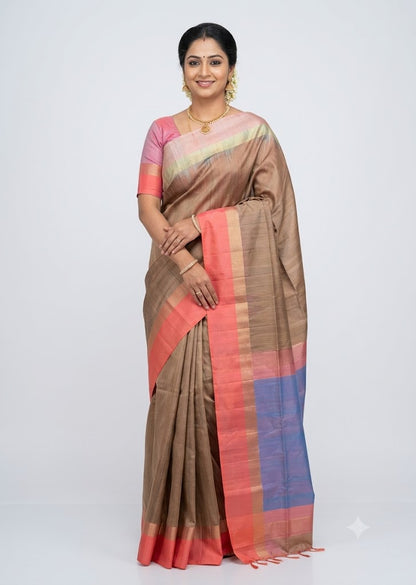 Indian model posing in a beige soft silk saree with coral pink border and blue contrast pallu