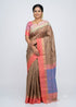 Indian model posing in a beige soft silk saree with coral pink border and blue contrast pallu