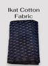 Folded black Pochampally Ikat cotton fabric featuring scattered horizontal white and reddish-brown woven dash motifs.