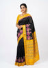 Elegant female model wearing a black and mustard yellow Pochampally Ikat silk saree with pink elephant motifs, paired with a matching embroidered yellow blouse.