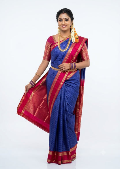 Traditional woman wearing royal blue Kanchi silk saree with red zari checks pallu and matching blouse on white background