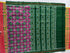 Flat lay of an authentic double ikat patola silk saree with a bold green body, large magenta circular motifs, green striped pallu, and Silk Mark certification