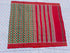 Flat lay of an authentic double ikat patola silk saree with a bold green patterned body, red striped pallu, and Silk Mark certification