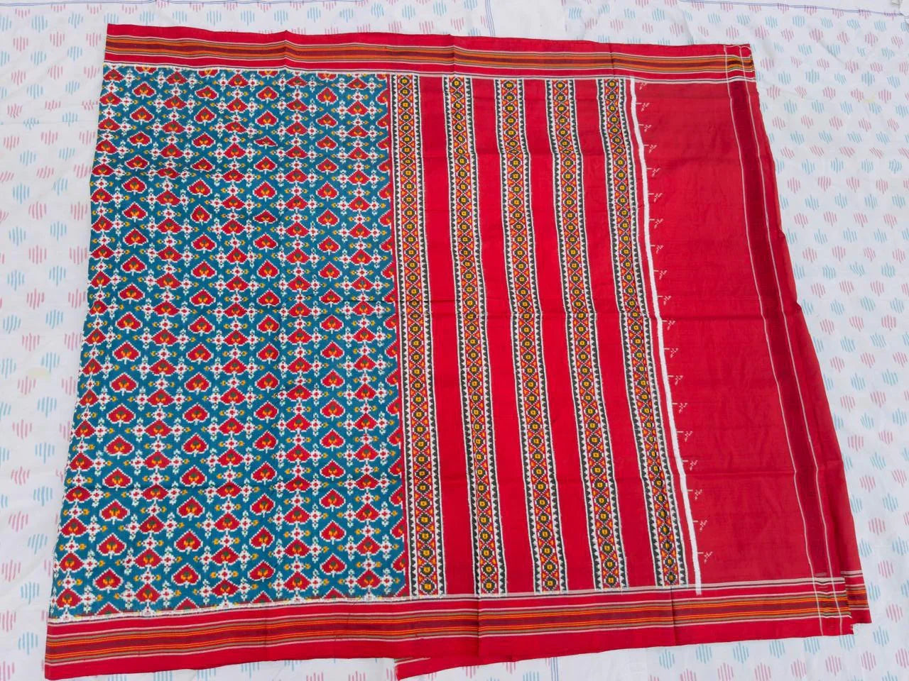 Flat lay of an authentic double ikat patola silk saree with a bold teal green patterned body, red striped pallu, and Silk Mark certification