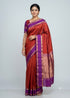 Traditional Indian woman standing in a full-length pose wearing a crimson red and royal purple Kanchi silk saree with gold zari border