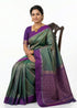 A beautiful woman wearing a vibrant soft silk saree with intricate zari work, styled with traditional jewelry.