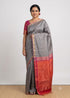 Model wearing an elegant grey silk saree featuring a rich rani pink and orange zari pallu with a matching rani pink short-sleeve blouse.