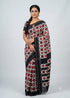 Traditional Indian woman draped in an authentic black and red Ikkat Telia Rumal cotton saree standing against a light grey studio backdrop.