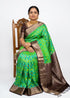 Elegant traditional green handloom Kanchi Ikat soft silk saree with intricate geometric patterns and a dark brown zari pallu.