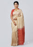 Traditional Indian model draped in a cream Kanchi soft silk saree featuring a delicate gold border and a contrasting red zari woven pallu.