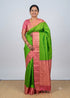 Indian model posing in a green Kanchi soft silk saree with a woven pink gold zari border and matching blouse