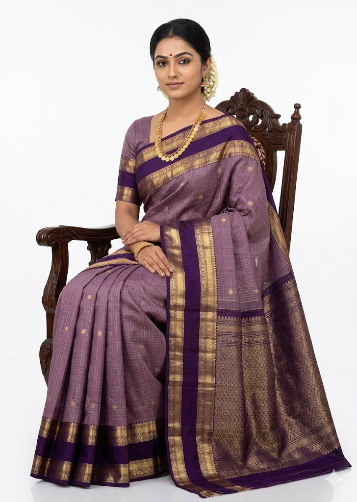 A traditional lavender Kanchipuram silk saree featuring gold zari checks and a contrasting deep purple border, elegantly draped.