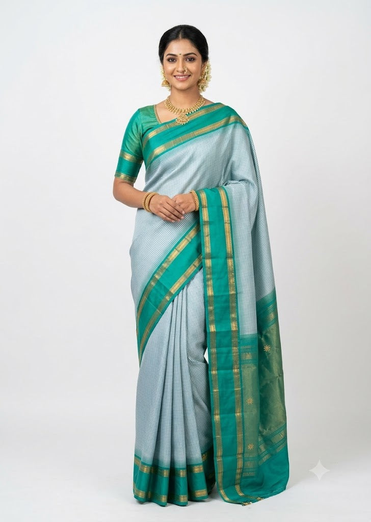 Model wearing a light blue checked Kanchi Silk Saree with emerald green zari border and blouse