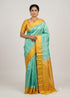 Traditional Indian woman wearing a light teal Kanchi soft silk saree with a golden border and embroidered yellow blouse