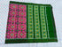 Flat lay of an authentic double ikat patola silk saree with a magenta geometric patterned body, bold green striped pallu, and Silk Mark certification