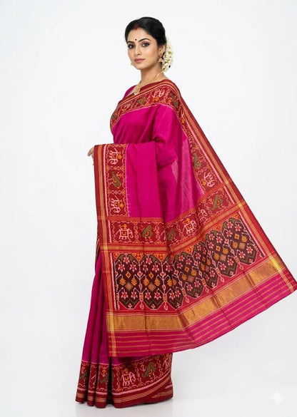 A beautiful Indian woman standing gracefully against a white background, wearing a vibrant magenta pure Patola silk saree. She is showcasing the saree&