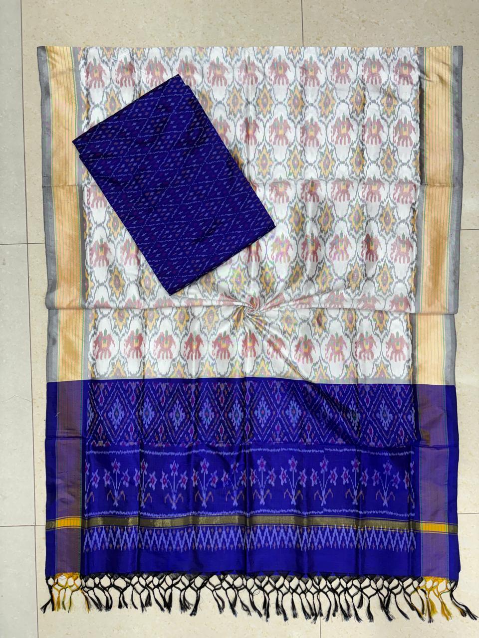 Off-white and royal blue Pochampally Ikat silk unstitched dress material set featuring handwoven elephant motifs, a detailed diamond and temple pattern border, and black and yellow tassels.