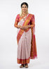Full-length flat lay view of a traditional off-white pure silk saree displaying a rich pink gold zari border and detailed paisley pallu.