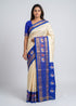 Traditional South Indian woman modeling an off-white handloom silk saree with a royal blue Ikkat elephant border and matching grid blouse, full front and back view on neutral background.