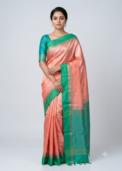 Indian model wearing a peach and teal green Kanchi soft silk saree with gold zari border against a neutral light grey backdrop