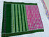 Flat lay of a pink double ikat patola silk saree featuring a contrasting dark green striped pallu and a Silk Mark certification
