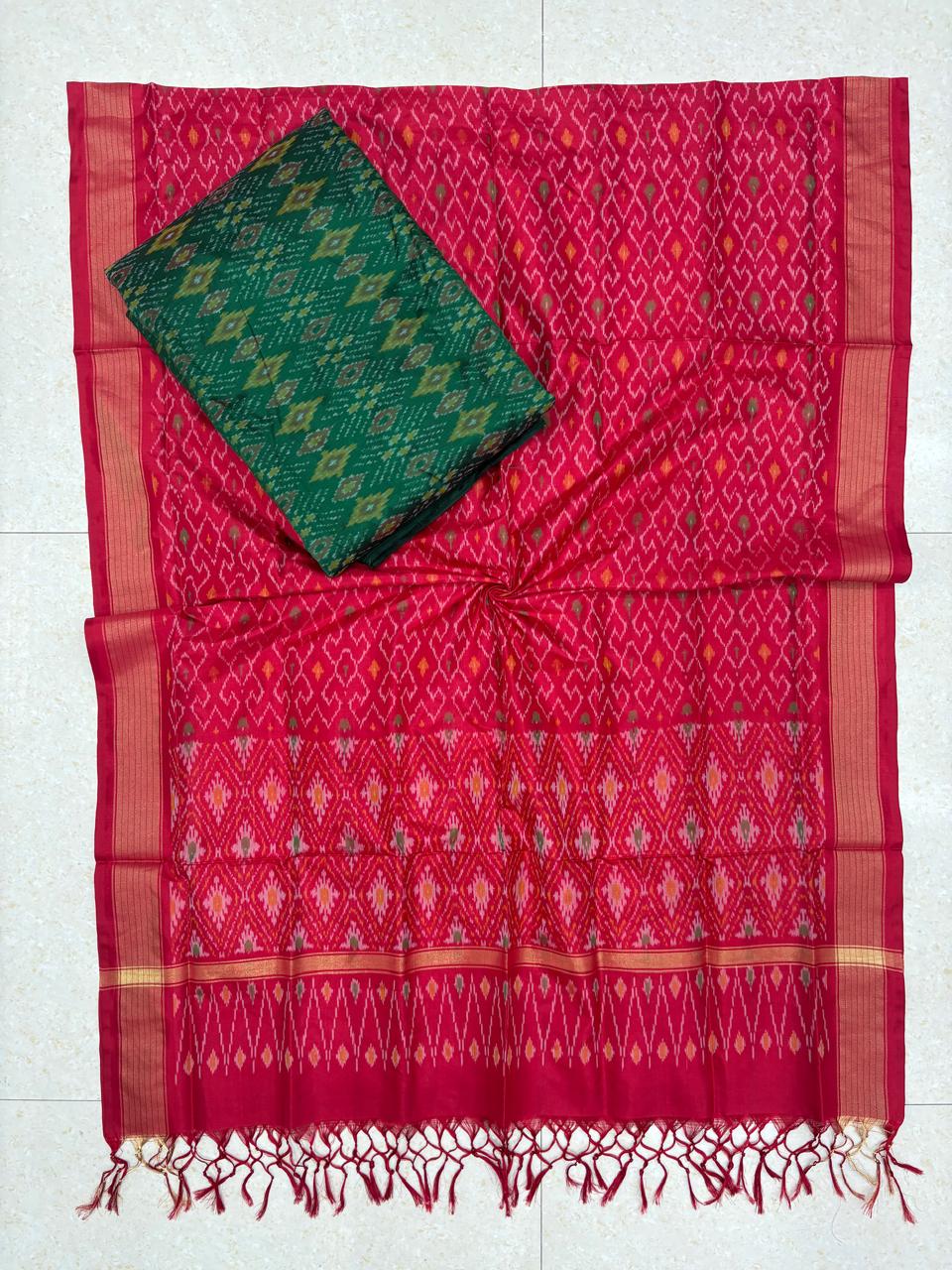 Vibrant pink and deep green Pochampally Ikat silk unstitched dress material set featuring traditional handwoven geometric motifs, gold-striped borders, and a matching pink tasseled dupatta.