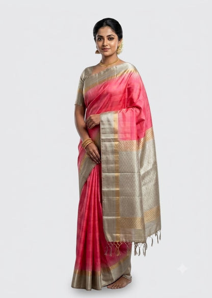 Model draping a pink Kanchi soft silk saree with a woven light gray silver zari pallu against a neutral backdrop