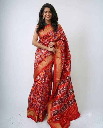 Beautiful woman wearing a traditional red Pochampally Ikkat Patola silk saree with gold zari border