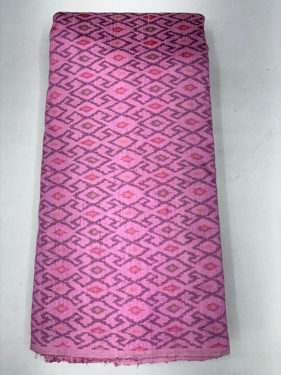 Folded bolt of dusty pink pure raw silk fabric featuring an interlocking geometric diamond Ikat weave with Silk Mark authenticity