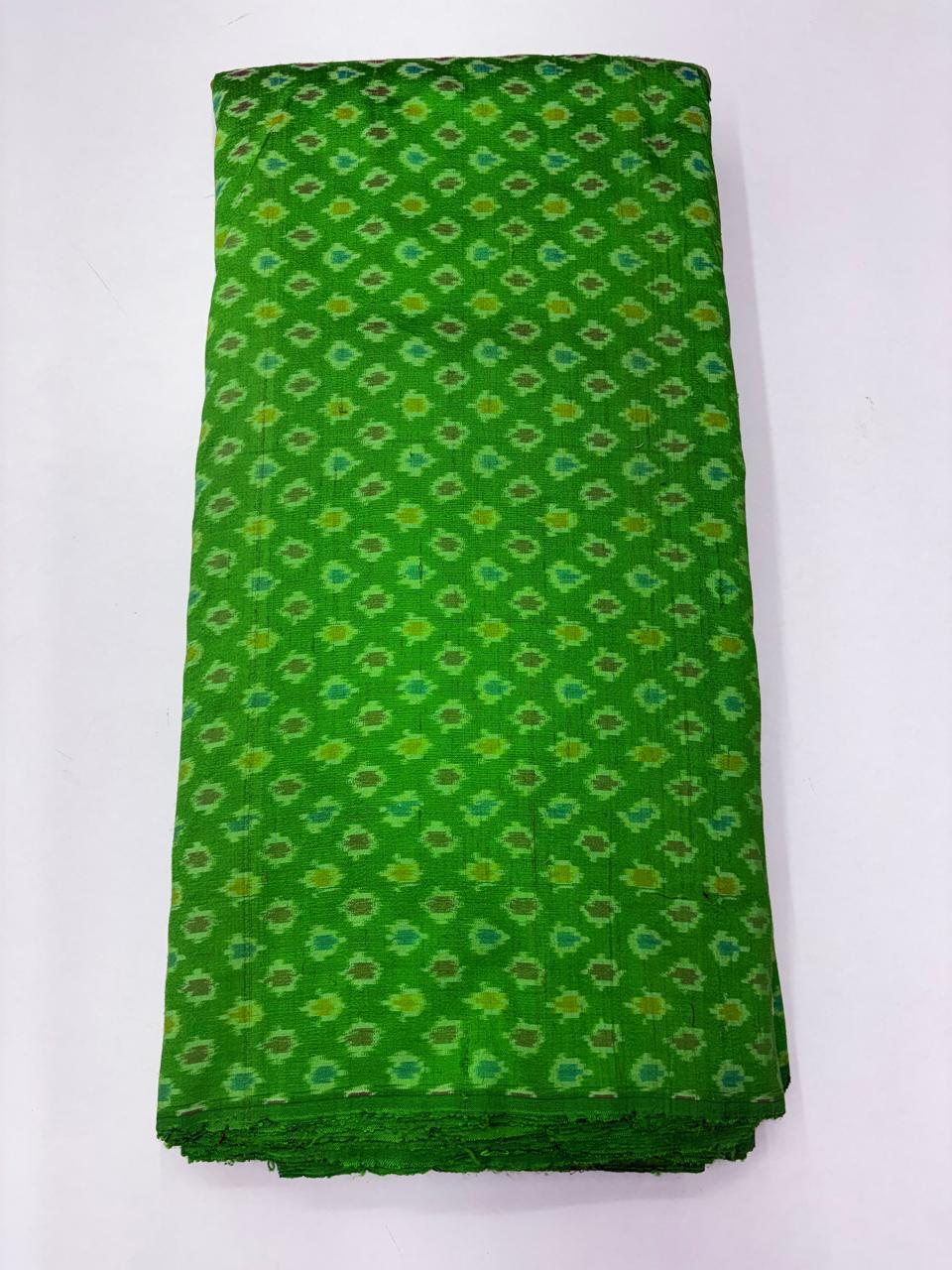 Folded bolt of bright parrot green pure raw silk fabric featuring diagonal geometric micro-Ikat motifs and Silk Mark quality weave