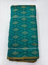 Folded bolt of teal green pure raw silk fabric featuring traditional geometric diamond Ikat motifs and Silk Mark quality weave