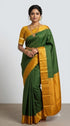 Model wearing authentic pure Kanchi soft silk saree in emerald green with mustard gold border and traditional jewelry