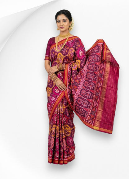 A woman wearing a beautiful pure real Patola silk saree in magenta and purple, showcasing an intricate traditional elephant and floral woven pallu.