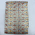 Folded ivory cream pure silk Ikat fabric featuring slate blue geometric diamond lattice with terracotta rust and mustard motifs with Silk Mark certification