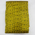 Folded mustard yellow pure silk Ikat fabric featuring olive green geometric diamond motifs with Silk Mark certification.
