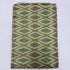 Folded pale sage cream pure silk Ikat fabric featuring olive green, mustard yellow, and rust geometric diamond patterns with Silk Mark certification