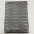 Folded slate grey pure silk Ikat fabric featuring linear silver-white leaf motifs and muted mauve accents with Silk Mark certification